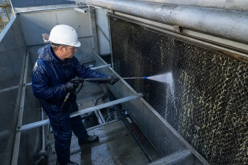 technician cleaning cooling tower water distribution system