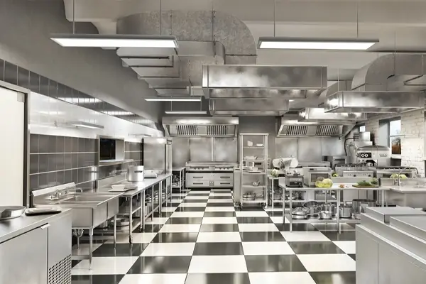 Commercial kitchen with stainless steel exhaust hoods and ductwork over the cooking line