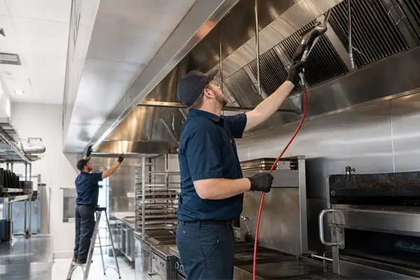 Commercial kitchen exhaust hood interior showing grease accumulation before cleaning