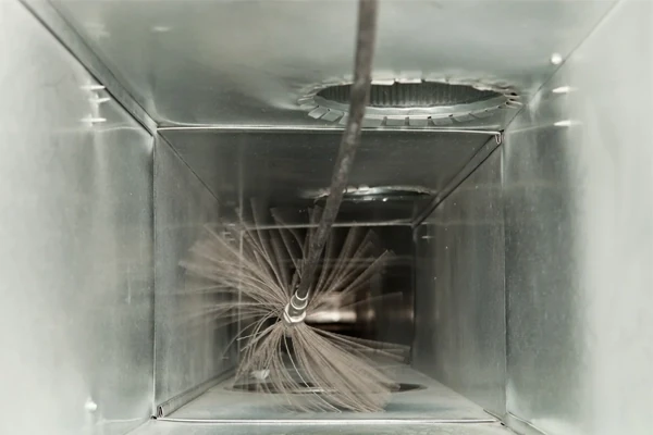 Rotating brush cleaning the inside of a sheet metal duct