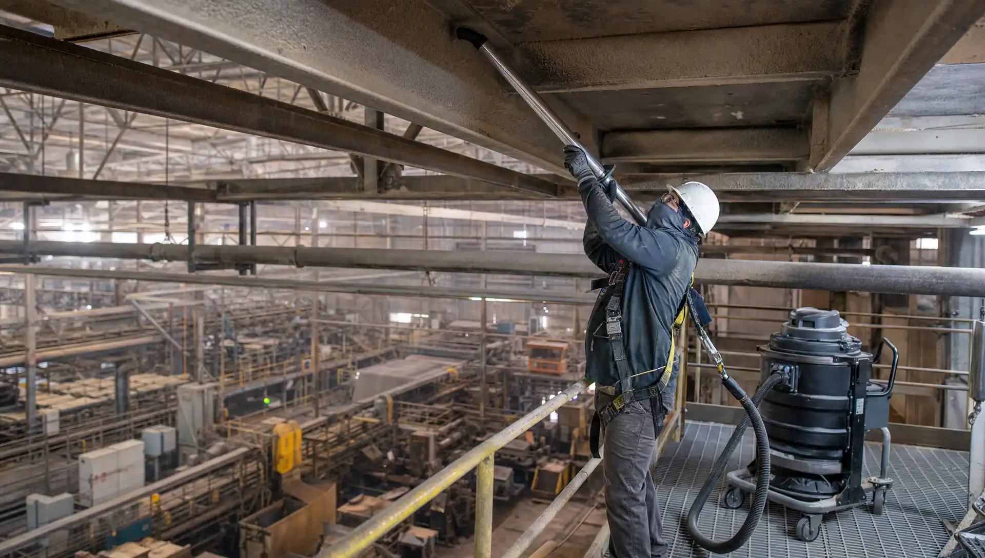 Service-Tech crew HEPA-vacuuming combustible paper dust from overhead steel during a planned mill outage near Pine Bluff, Arkansas